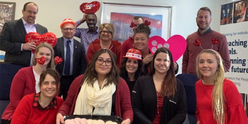 Employees dressed in red, celebrating Giving Hearts Day.