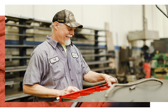 Mechanic smiling behind a tool set.