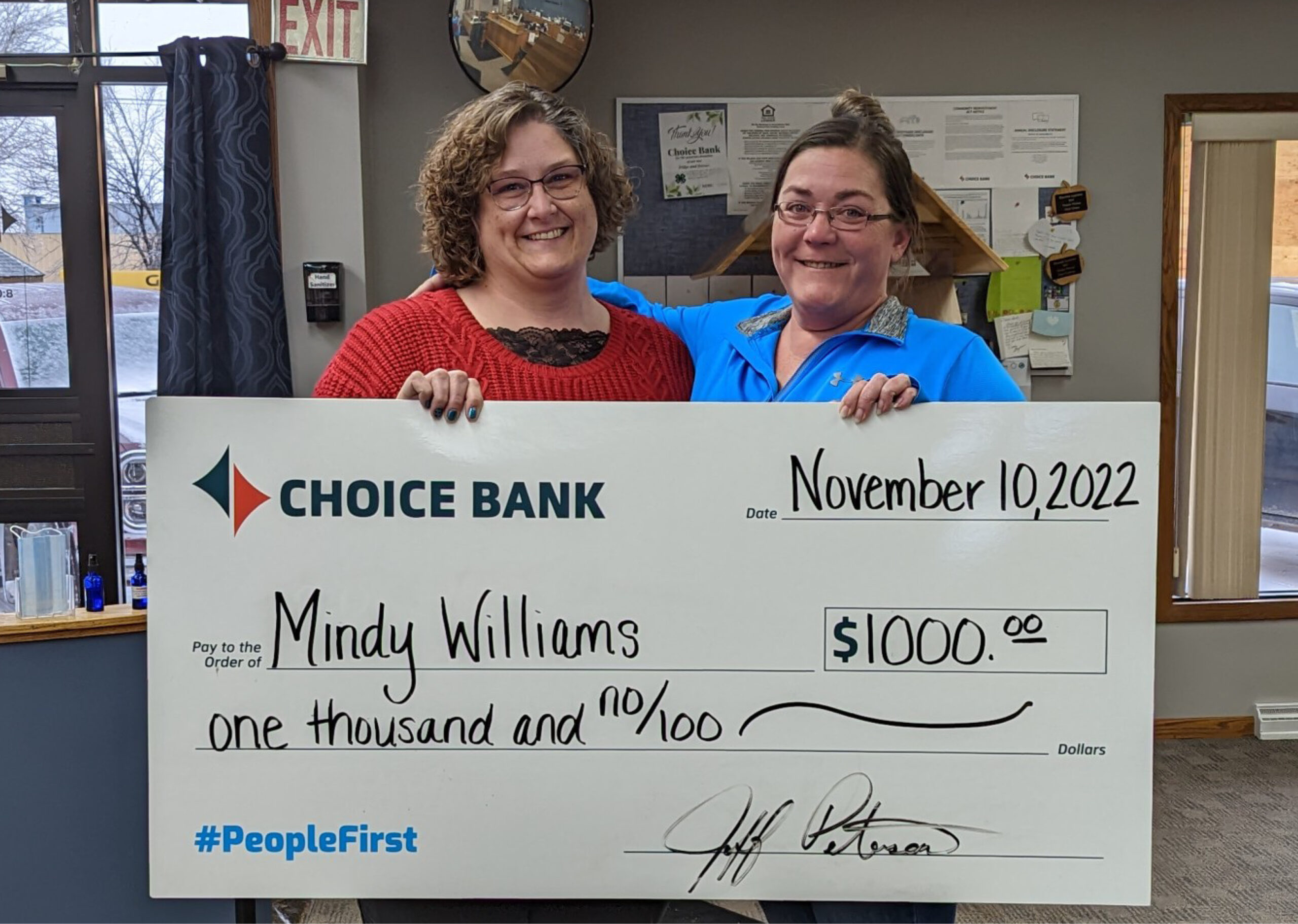 Two women hold a giant check