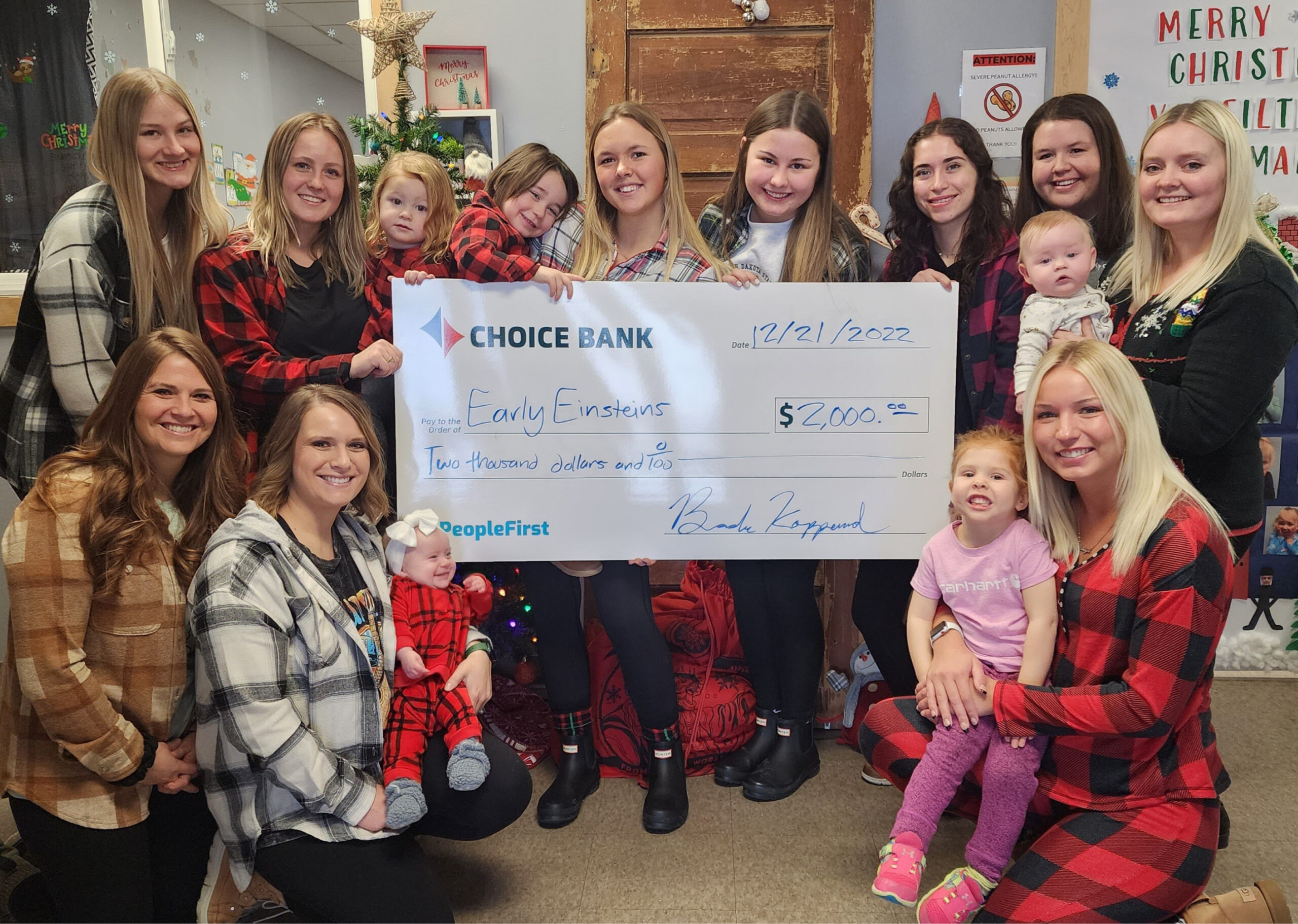 a group of women and children with a donation check