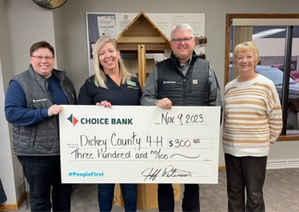 bank employees present a donation check to a woman