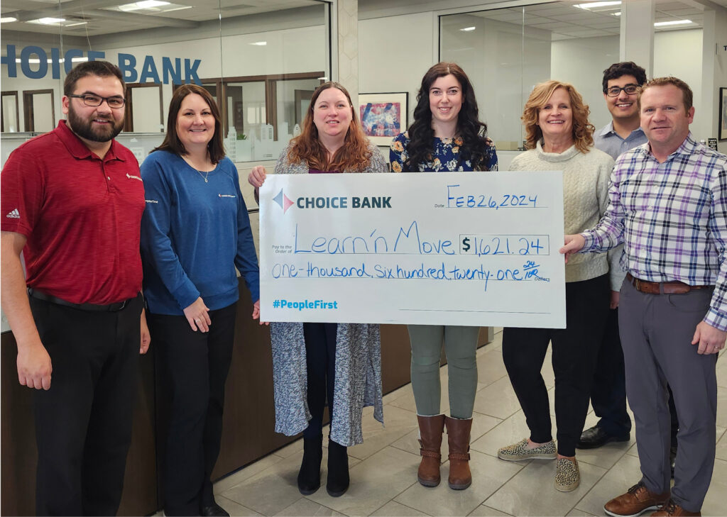bank employees present daycare owner with a donation