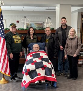man with quilt and family