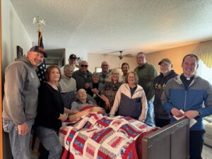 man with quilt and family