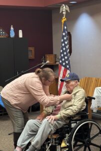 man receives pin for military service